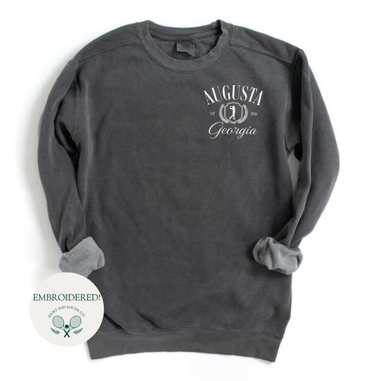 Augusta Georgia embroidered Comfort Colors crewneck sweatshirt with vintage retro golf-inspired design. White embroidery on the left chest pocket area, 4 inches wide, on a soft, garment-dyed pullover.