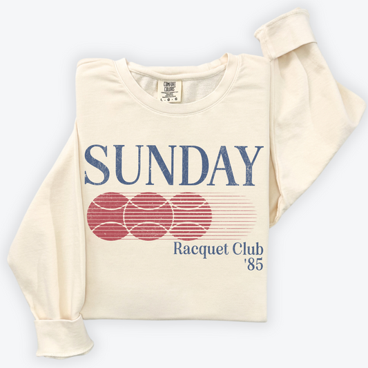 Sunday Racquet Club '85 lightweight cotton crewneck with a vintage retro 80s vibe, featuring bold nostalgic typography on soft cotton fabric.