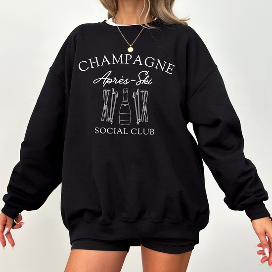 Midweight fleece crewneck sweatshirt with "Champagne Après Ski Social Club" vintage design, perfect for après-ski gatherings and cozy winter wear.