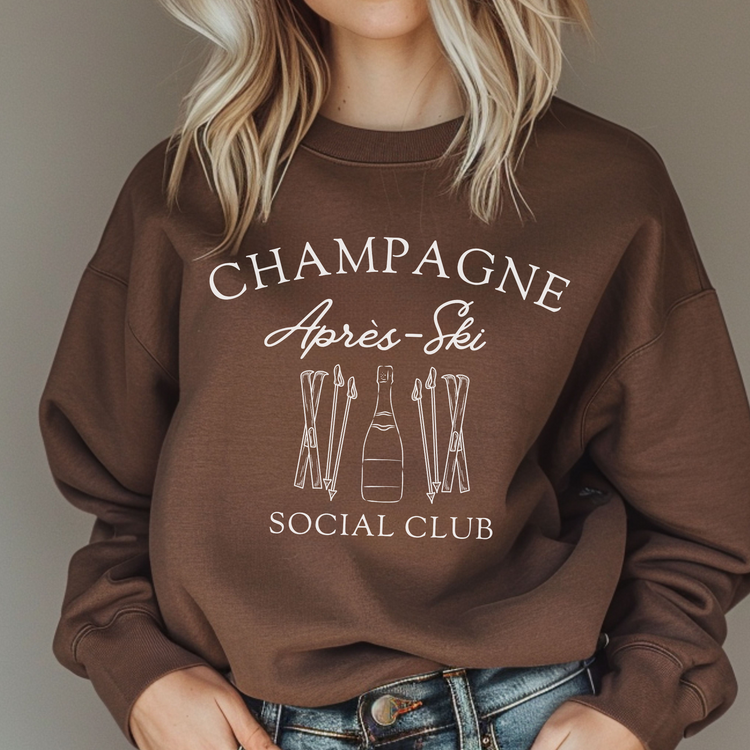 Midweight fleece crewneck sweatshirt with "Champagne Après Ski Social Club" vintage design, perfect for après-ski gatherings and cozy winter wear.