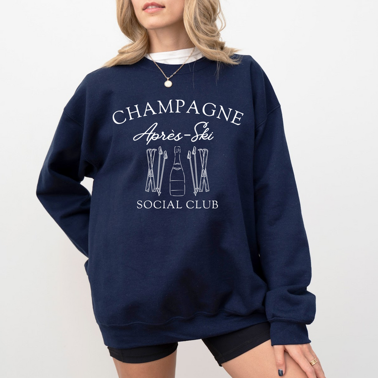 Midweight fleece crewneck sweatshirt with "Champagne Après Ski Social Club" vintage design, perfect for après-ski gatherings and cozy winter wear.