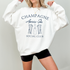 Midweight fleece crewneck sweatshirt with "Champagne Après Ski Social Club" vintage design, perfect for après-ski gatherings and cozy winter wear.