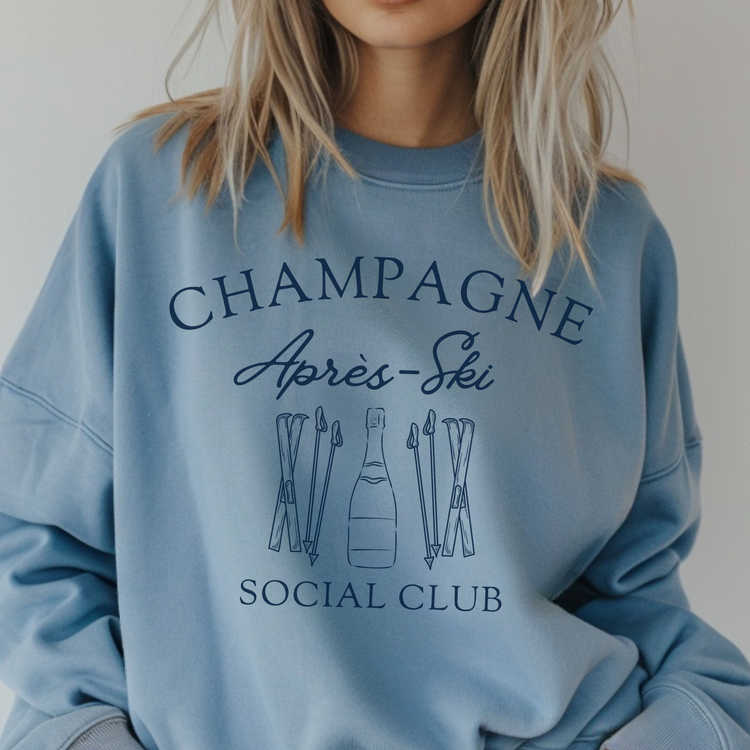 Midweight fleece crewneck sweatshirt with "Champagne Après Ski Social Club" vintage design, perfect for après-ski gatherings and cozy winter wear.