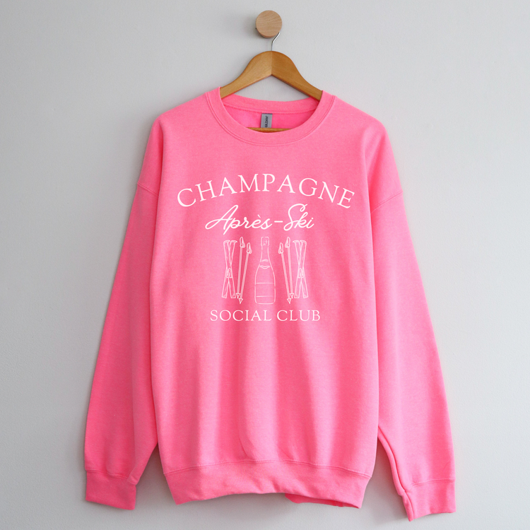 Midweight fleece crewneck sweatshirt with "Champagne Après Ski Social Club" vintage design, perfect for après-ski gatherings and cozy winter wear.