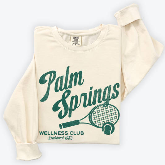 Palm Springs Wellness Club crewneck sweatshirt with a retro tennis racquet graphic in vintage grunge print, perfect for athleisure or casual wear.