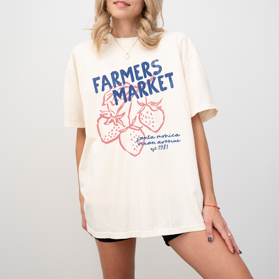 Comfort Colors short sleeve t-shirt with "Santa Monica Farmers Market" in vintage retro style, featuring boho strawberries for a California-inspired, relaxed market look.