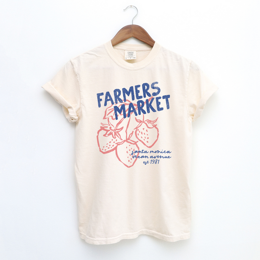 Comfort Colors short sleeve t-shirt with "Santa Monica Farmers Market" in vintage retro style, featuring boho strawberries for a California-inspired, relaxed market look.