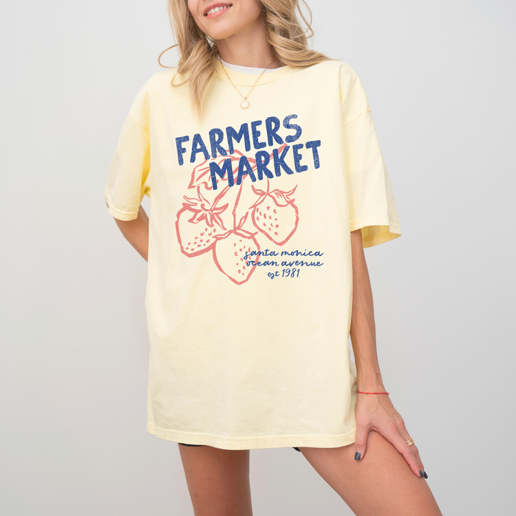 Comfort Colors short sleeve t-shirt with "Santa Monica Farmers Market" in vintage retro style, featuring boho strawberries for a California-inspired, relaxed market look.