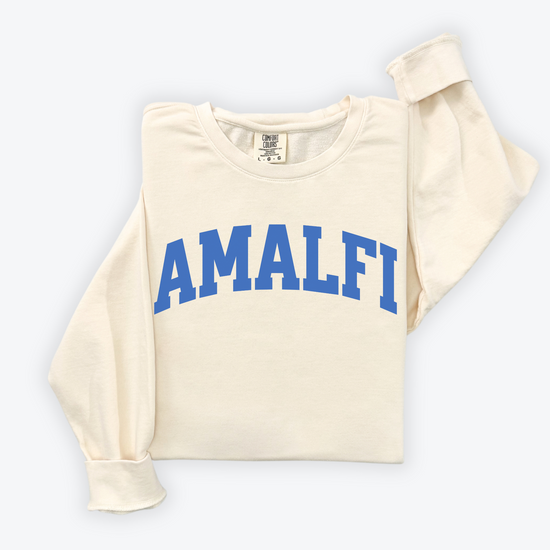 Flatlay image of a lightweight Comfort Colors sweatshirt in soft cotton with 'Amalfi' printed in a sporty, university-style font across the chest. The relaxed, casual fit and vintage-inspired design give the sweatshirt a cozy, well-loved look