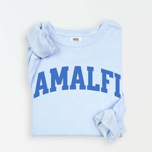 Flatlay image of a lightweight Comfort Colors sweatshirt in soft cotton with 'Amalfi' printed in a sporty, university-style font across the chest. The relaxed, casual fit and vintage-inspired design give the sweatshirt a cozy, well-loved look