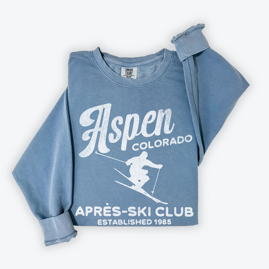 Unisex lightweight cotton Comfort Colors crewneck sweatshirt with "Aspen Après Ski Club" in vintage retro grunge style print, designed for men and women