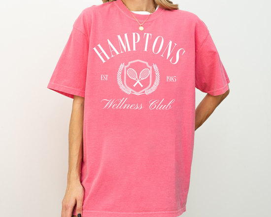 Hamptons Wellness Club short sleeve t-shirt with retro tennis graphics, worn by a model, pink shirt with white print