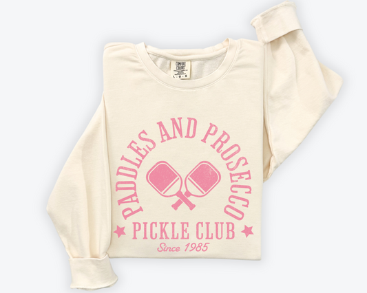 Paddles and Prosecco Pickle Club lightweight cotton crewneck sweatshirt with a pink vintage, faded print, font, folded view, ivory color